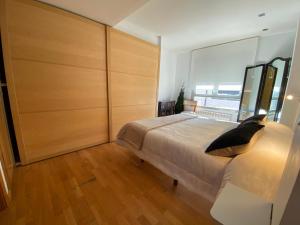ein Schlafzimmer mit einem großen Bett und einem großen Fenster in der Unterkunft Valdevebas Chalet con Piscina in Madrid