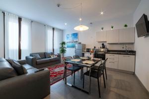 a kitchen and a living room with a table and chairs at Ca' degli Specchieri in Venice