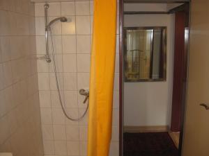 a shower with a yellow curtain in a bathroom at Main-Kinzig Gästewohnung in Hasselroth