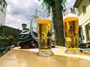 zwei Gläser Bier auf einem Holztisch in der Unterkunft Am Bungert in Mayschoß