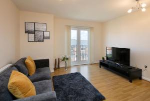 a living room with a couch and a flat screen tv at Solihull Birmingham Coventry NEC Long & Short Stay Contractors HS2 BHX Sleeps 3 persons 2 Bedrooms 2 Bathroom Apartment Dedicated Parking Close to NEC City Centre International Airport & Train Station Business Travellers in Birmingham