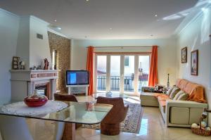 a living room with a couch and a fireplace at Rancho Mar à Vista in Atalaia de Cima