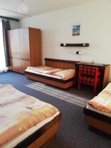 a hotel room with three beds and a desk at ABC Hotel Nitra in Nitra