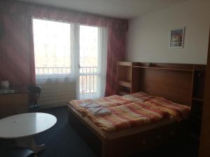 1 dormitorio con cama, mesa y ventana en ABC Hotel Nitra, en Nitra