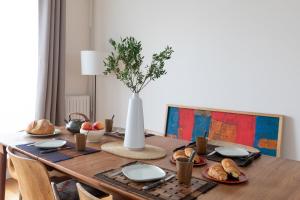 a dining room table with a vase with food on it at Paris-Maison-appartement-7 chambres métro Jourdain in Paris