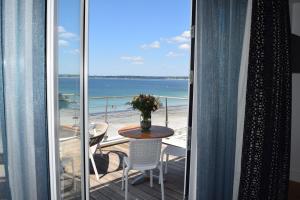 balcone con tavolo, sedie e vista sull'oceano di Les Sables Blancs a Concarneau