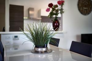 a glass table with a vase of grass on it at Your Familyapartment in Sirmione in Sirmione