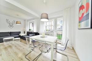 sala de estar con mesa blanca y sillas en Apartament Karpatka, en Karpacz