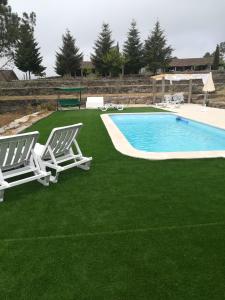a pair of lawn chairs and a swimming pool at Museu Casa Aleixo in Sernancelhe