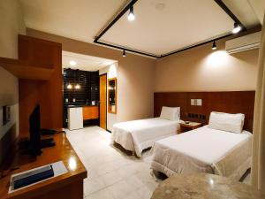 a hotel room with two beds and a television at Savassi Village in Belo Horizonte