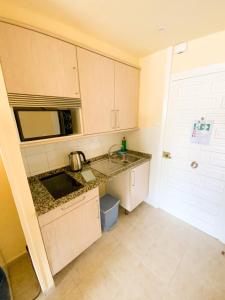 a small kitchen with a sink and a microwave at Kingfisher Apartments Benal Beach in Benalmádena