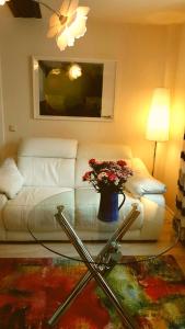 a living room with a white couch with a vase of flowers at Altstadtapartment an der Krämerbrücke Nr.2 in Erfurt