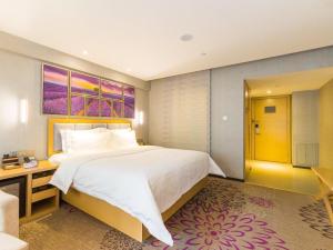 a hotel room with a large bed and a desk at Lavande Hotel Xining Haihu New District Wanda Plaza in Xining