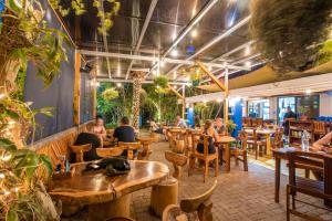 ein Restaurant mit Holztischen und Tischen in der Unterkunft Playa Grande Surf Camp in Playa Grande