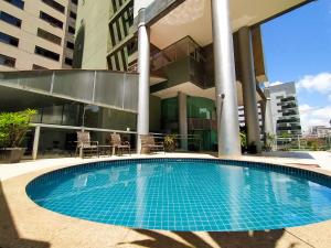 a swimming pool in front of a building at Village Savassi in Belo Horizonte