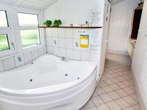 a large white tub in a bathroom with windows at 7 person holiday home in Hemmet in Falen