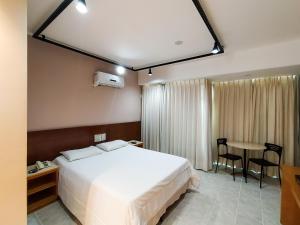 a hotel room with a bed and a table at Savassi Village in Belo Horizonte