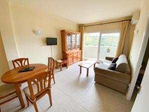 - un salon avec une table et un canapé dans l'établissement Kingfisher Apartments Benal Beach, à Benalmádena