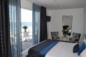 a bedroom with a bed and a view of the ocean at Les Sables Blancs in Concarneau