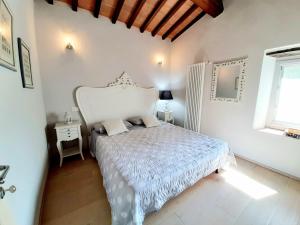 um quarto com uma cama branca e uma janela em Villa Galearpe with private pool in Tuscany em Salutio