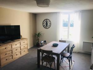 a dining room with a table and a clock on the wall at Au pied du Chateau de Chaumont sur Loire in Chaumont-sur-Loire