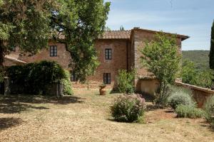 an old brick house with a yard in front of it at Casa al Gianni in Sovicille