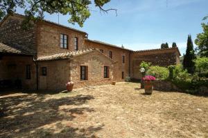 a large brick building with flowers in a yard at Casa al Gianni in Sovicille