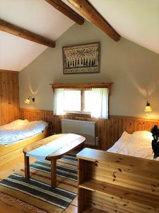 Un dormitorio con 2 camas y un banco. en Villa Klockarbo - Stugor - Cabins, en Tällberg