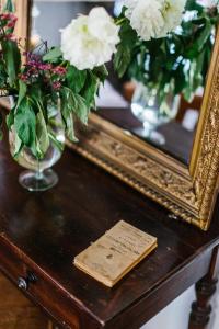 a table with vases of flowers and a mirror at Borgo Lu Puleu in Perfugas