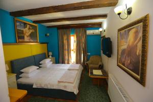 ein Schlafzimmer mit einem Bett in einem blauen Zimmer in der Unterkunft Hotel Konak Tammy Platičevo - Šabac in Šabac