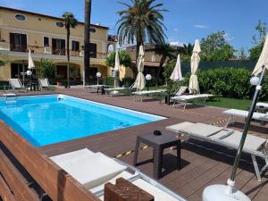 a pool with chairs and umbrellas next to a building at VILLA LUCIA in Castellammare di Stabia