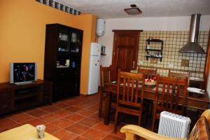 a kitchen with a table and chairs and a television at Casa Rural La Casa de La Lima in Las Rosas