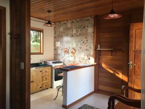 a kitchen with a stove and a white counter top at Pedacinho de Chão Chalés in Visconde De Maua