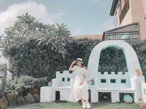 a woman standing in front of a white bench at Happiness Factory in Huxi