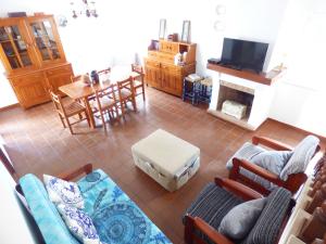 a living room with a couch and a table and a tv at Apartamento Rosa in Vila Nova de Milfontes