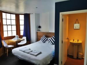 a bedroom with a bed and a desk and a window at Number 75 in Brighton & Hove