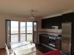 - une cuisine avec une table et une vue sur l'océan dans l'établissement Apartamento Playa de Boiro, à Boiro