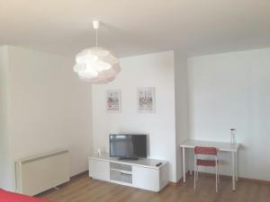 - un salon avec une table, une télévision et une lampe dans l'établissement Apartamento Playa de Boiro, à Boiro