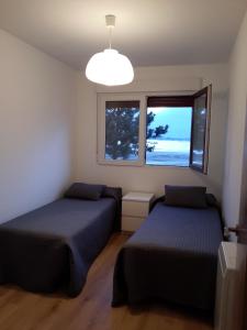 una camera con due letti e una finestra di Apartamento Playa de Boiro a Boiro