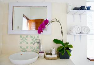 a bathroom with a sink and a flower on the counter at Aryautama Garden Villa in Munduk
