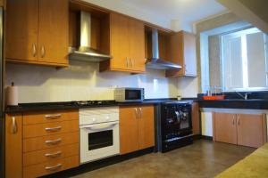a kitchen with wooden cabinets and a microwave at Casa do Rei in Boiro