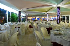 a banquet hall with white tables and white chairs at Torre Del Sole in Terracina