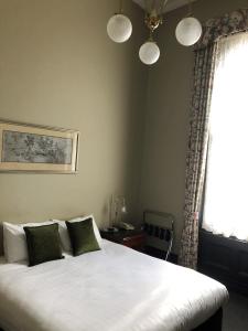 a bedroom with a bed and a window at Vue Grand Hotel in Queenscliff