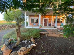 a small house with a stone walkway in front of it at Black Beach House in Floreana