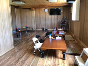 a room with tables and chairs and a flat screen tv at 東のオズ in Higashi