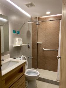 a bathroom with a shower and a toilet and a sink at Microtel by Wyndham Tarlac in Tarlac