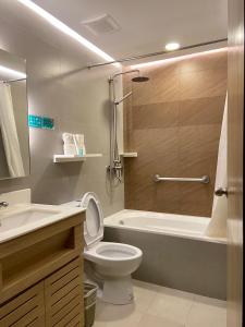 y baño con aseo, bañera y lavamanos. en Microtel by Wyndham Tarlac, en Tarlac