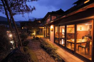 ein Gebäude mit einem Tisch und Stühlen außerhalb des Gebäudes in der Unterkunft Shimizu Ryokan in Yufu