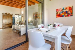 a dining room with a white table and white chairs at Nonna Germina in Roccalumera