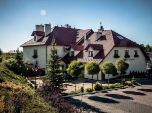 a large white house with a red roof at Gościniec Na Rozdrożu in Libiąż